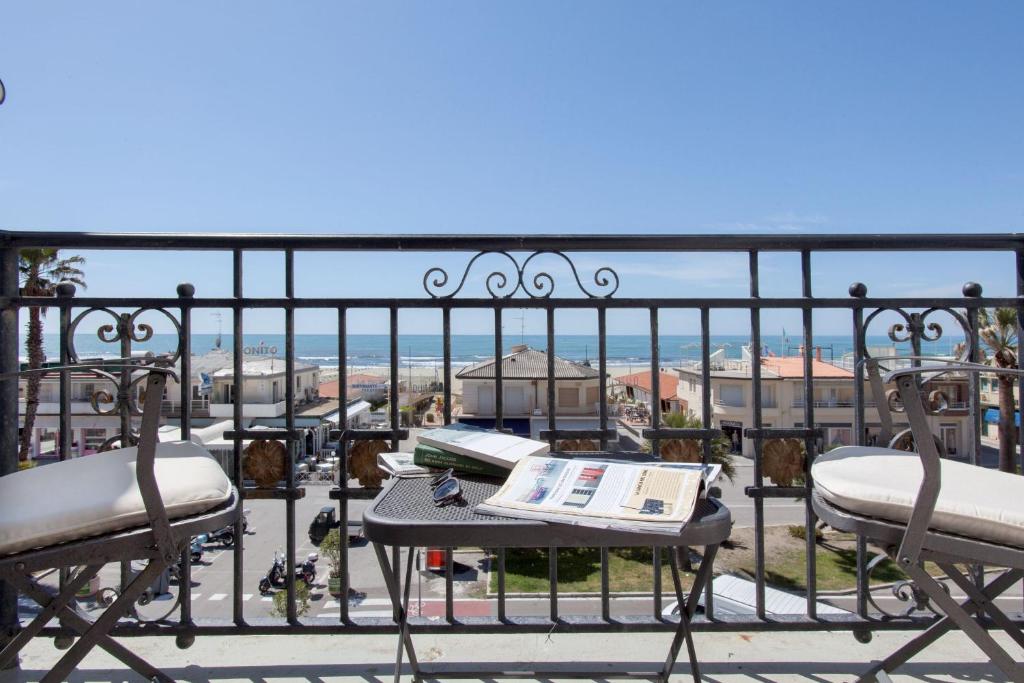 a balcony with two chairs and a table with a book at Palace Hotel in Viareggio