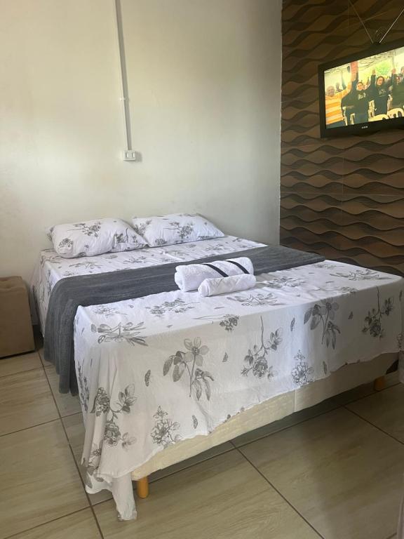 a bedroom with a bed with a table with a blanket at Rosy Flat 1 Andar in Petrolina