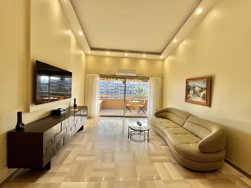un salon avec un canapé et une télévision dans l'établissement Astoria luxury apartment- 3 bathrooms, à Cannes