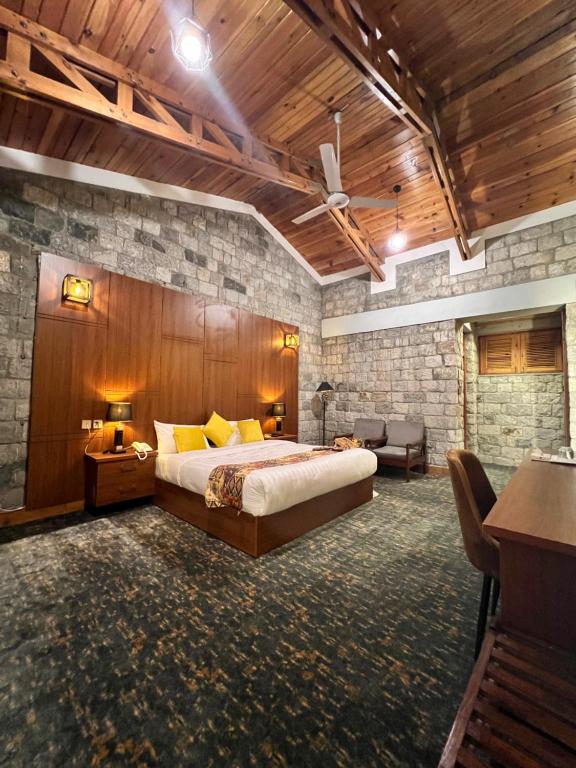 a bedroom with a king sized bed and a stone wall at Destination Hotel Khaplu in Khaplu