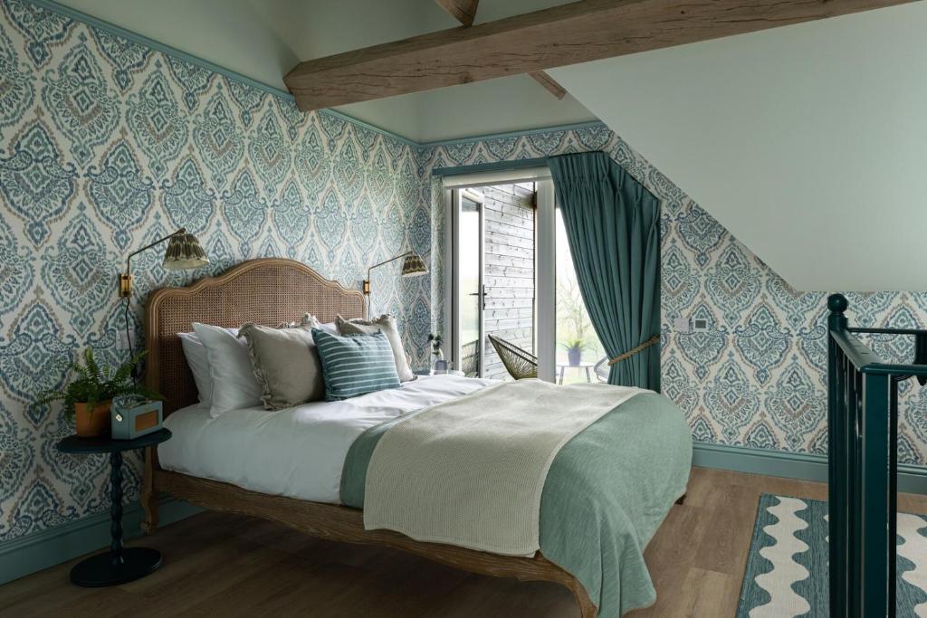 a bedroom with a bed with blue and white wallpaper at Owl's Perch - Otium Wine Estate in Alton