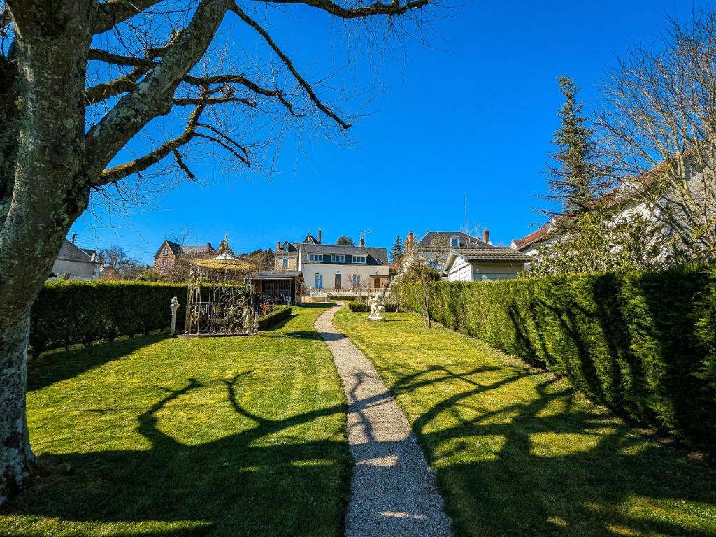 a pathway through a yard with a house in the background at Maison d'hôtes de charme du XIXe, proche Château de Valençay et Zoo de Beauval - FR-1-591-392 in Valençay
