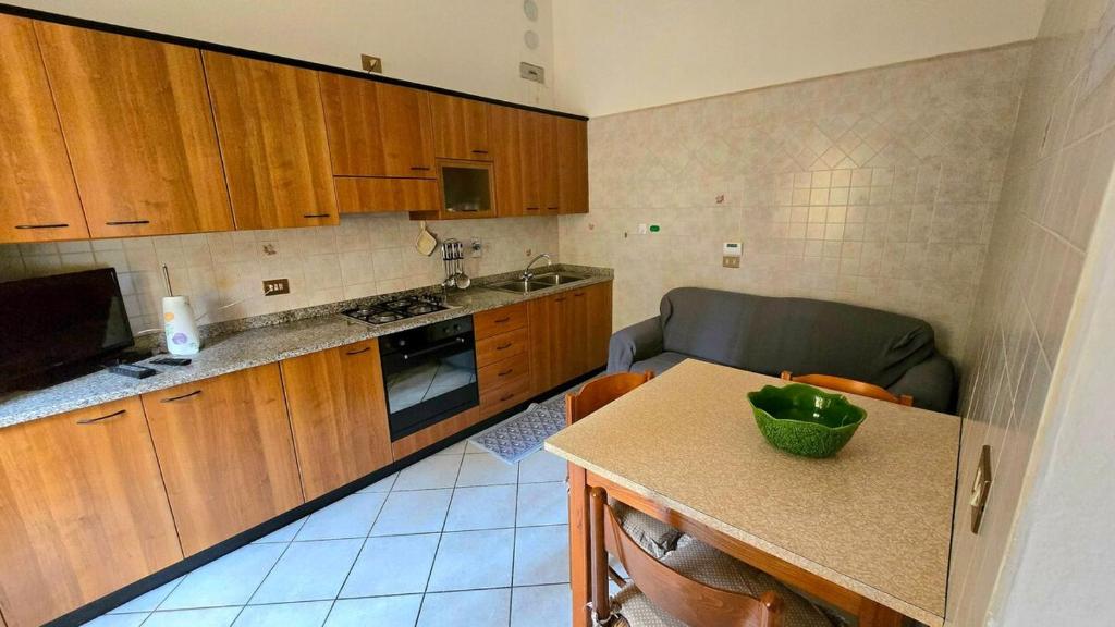 eine Küche mit Holzschränken und einem Tisch mit einer Schüssel darauf in der Unterkunft Guest house Pietracolora in Pietracolora