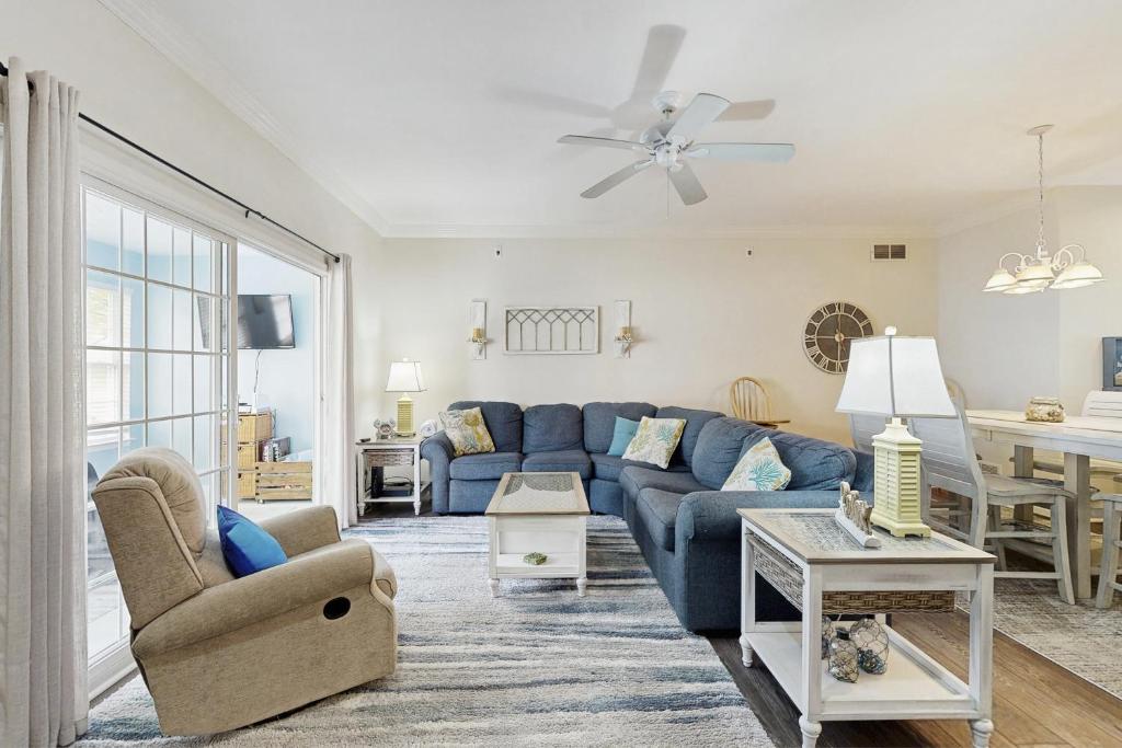 リホボスビーチにあるBella Vista --- 20369 Adriana Lnの青いソファとテーブルのあるリビングルーム