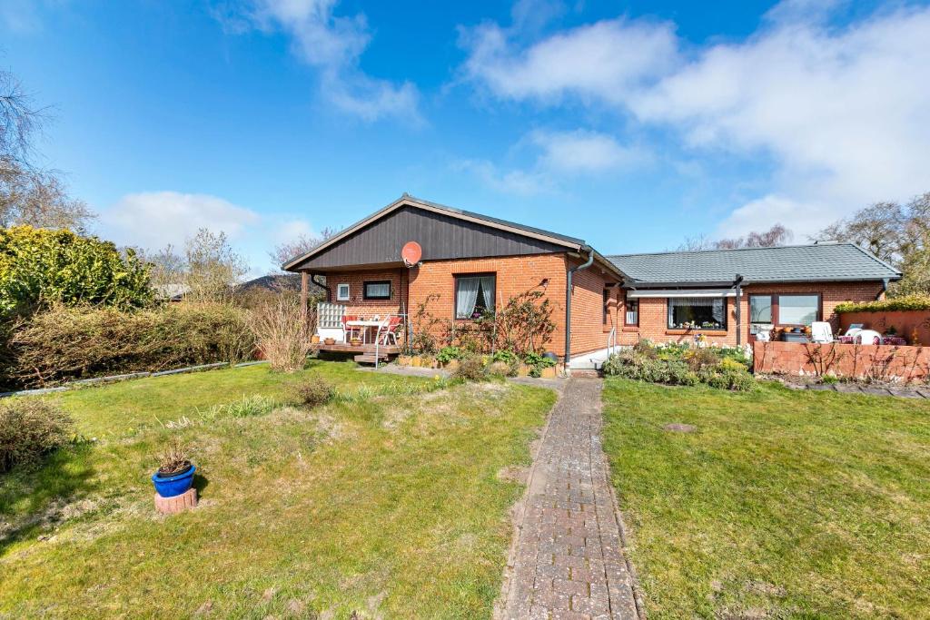 ein Haus mit einem Backsteinpfad davor in der Unterkunft Grenznah Garten Ruhig in Ladelund