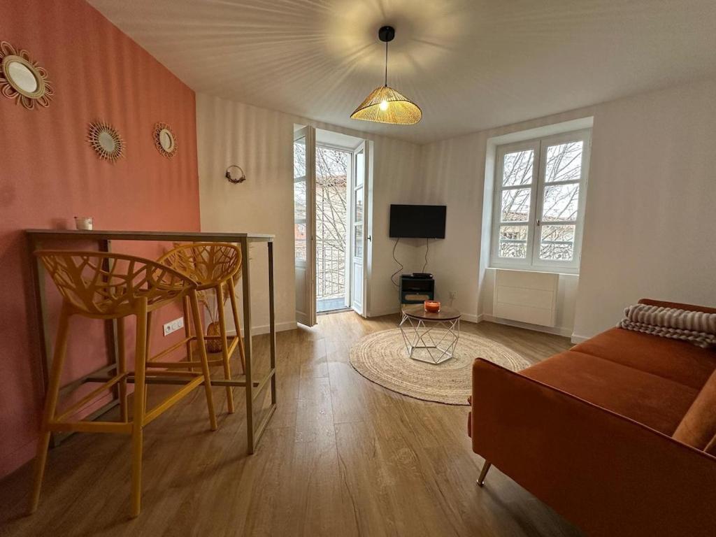 un salon avec un lit et une table dans l'établissement Charmant avec petit balcon au coeur du village, à Thurins