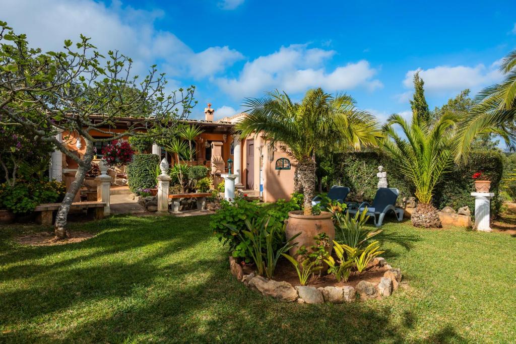 a house with palm trees and a yard at Finca Ladimora in Capdepera