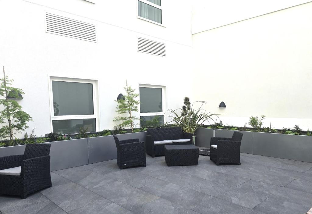 a patio with chairs and tables in front of a building at Maldron Hotel Brighton City Centre in Brighton & Hove