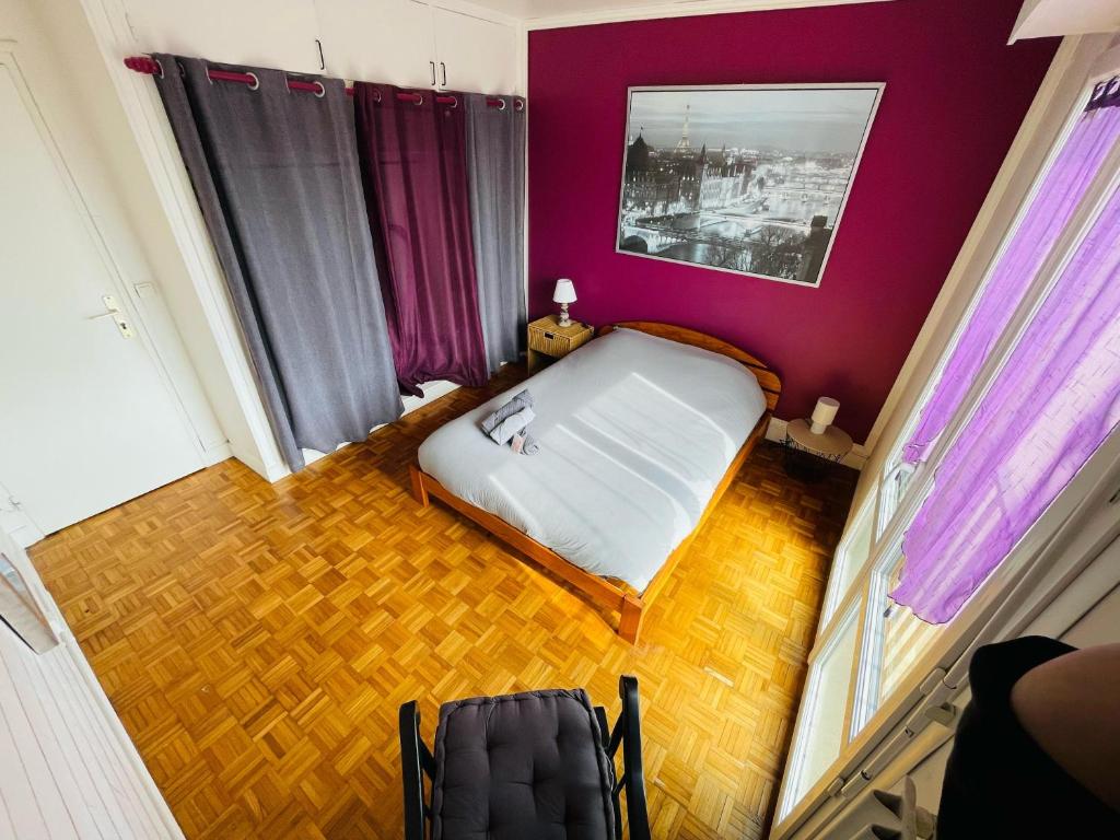 - une petite chambre avec un lit et des murs violets dans l'établissement Parenthèse de Calme - 380, à Rouen