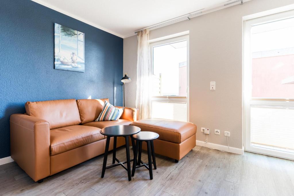 a living room with a leather couch and a table at Fehmarnstrand 78 App 9 in Staberdorf
