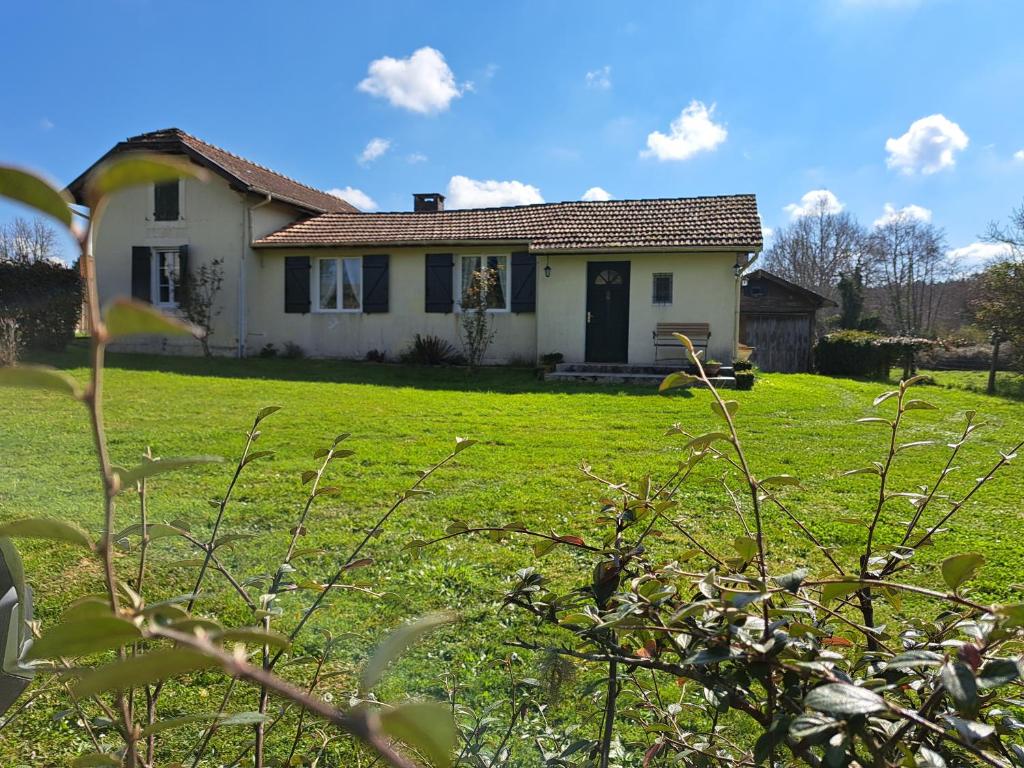 une petite maison blanche avec une cour gazonnée dans l'établissement Refuge Champêtre, à Mézos