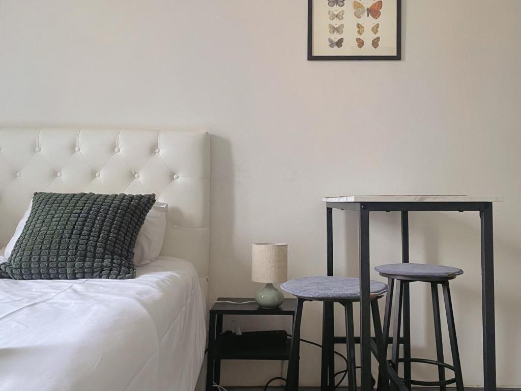 a bedroom with a bed and two stools next to a table at Nextdoor Host Eco-lodge 24h Self Check-in with Bathtub in Helsinki