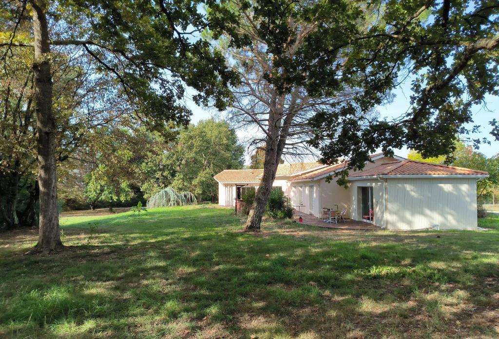a white house in a yard with trees at Lou barede in Montagne