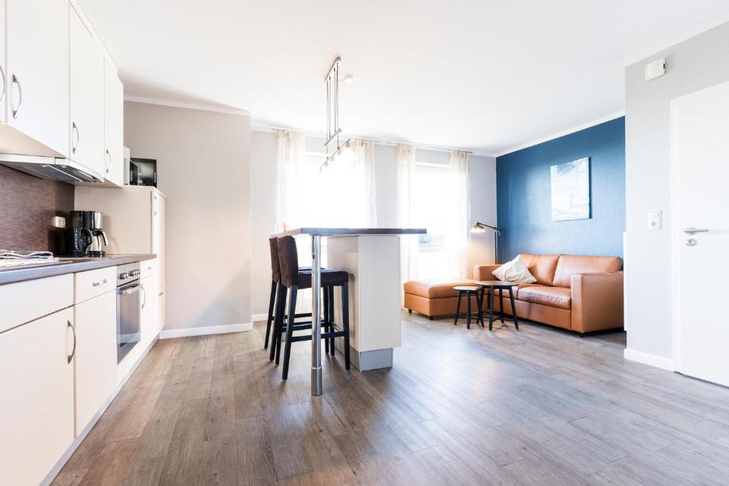 a kitchen and living room with a couch and a table at Fehmarnstrand 78 App 12 in Staberdorf