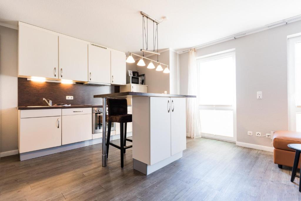 a kitchen with white cabinets and a counter in a room at Fehmarnstrand 78 App 10 in Staberdorf
