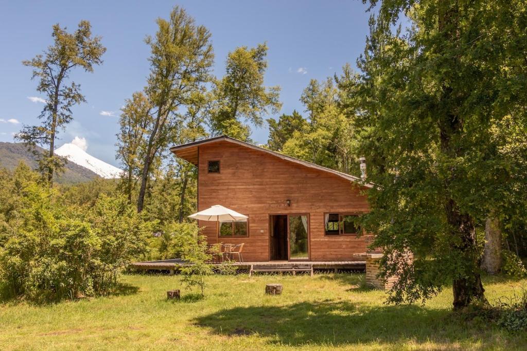 a log cabin in the middle of a field at Cabaña en Pucon in Pucón