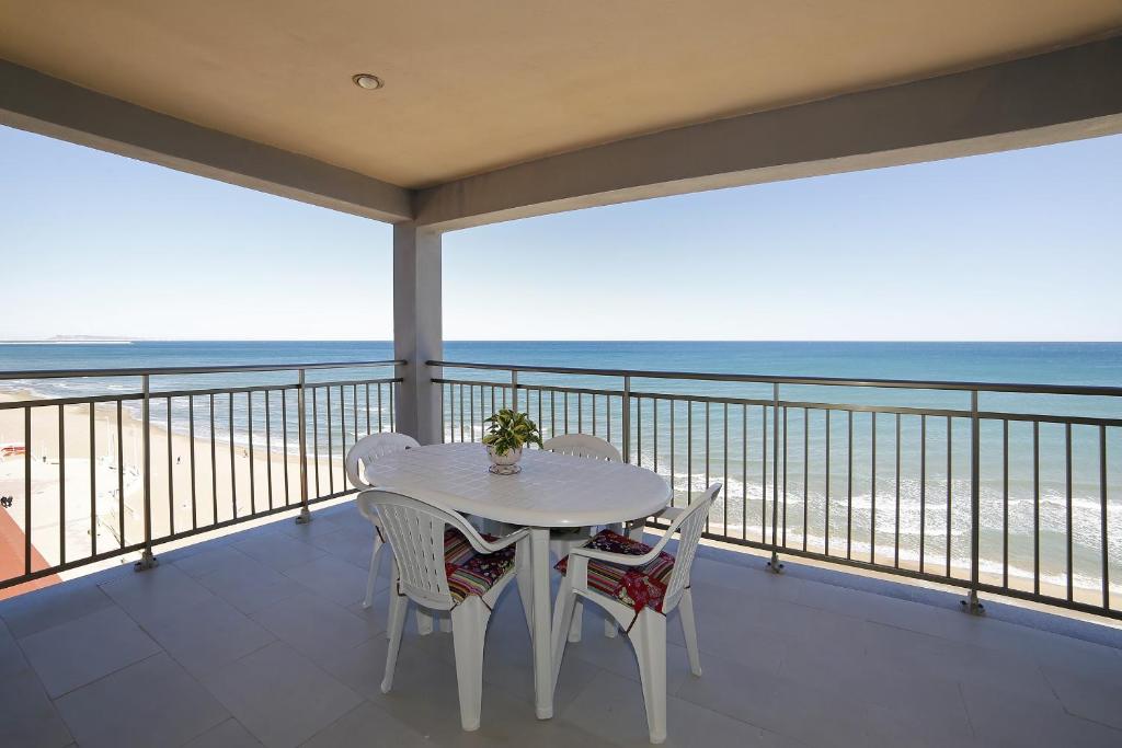 a white table and chairs on a balcony with the ocean at Apartamento Maria Jose in Playa de Miramar