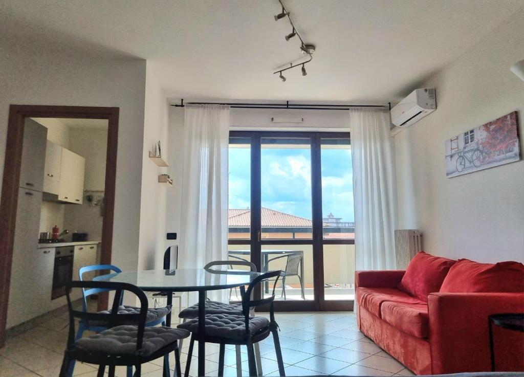 a living room with a table and a red couch at Studio with terrace in Busto Arsizio