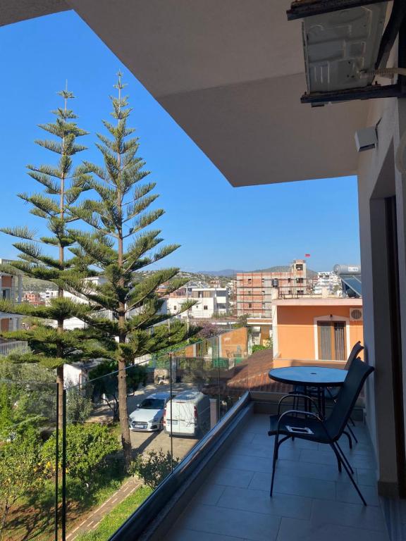 a tree on a balcony with a table and chair at Hotel Marku in Ksamil