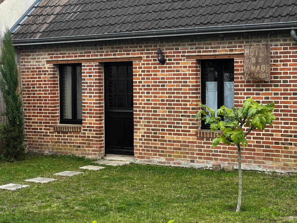 a brick house with a small tree in front of it at Hôtel de l image in Vouzon