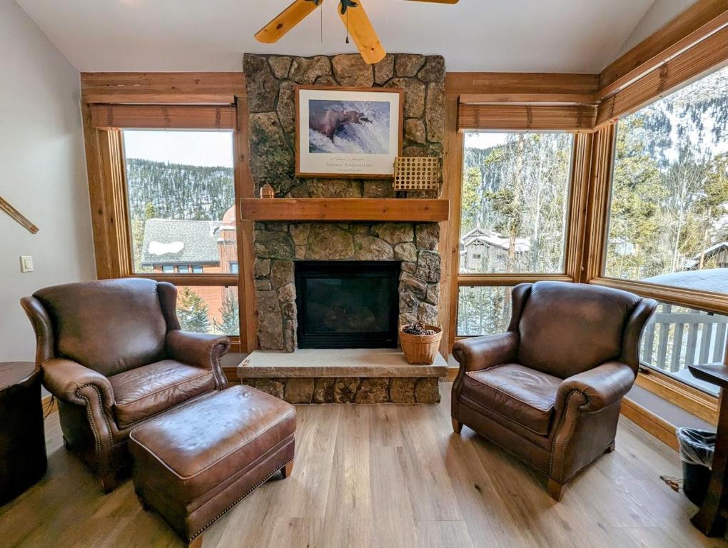 un soggiorno con due sedie e un camino di Settlers Creek 6517 by SummitCove Lodging a Keystone