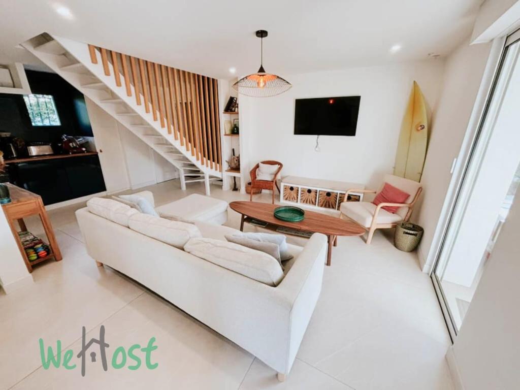 un salon avec un canapé blanc et une table dans l'établissement Kokomo - LB - PB - Beautiful Villa with Pool Parking St Jean de Luz, à Saint-Jean-de-Luz