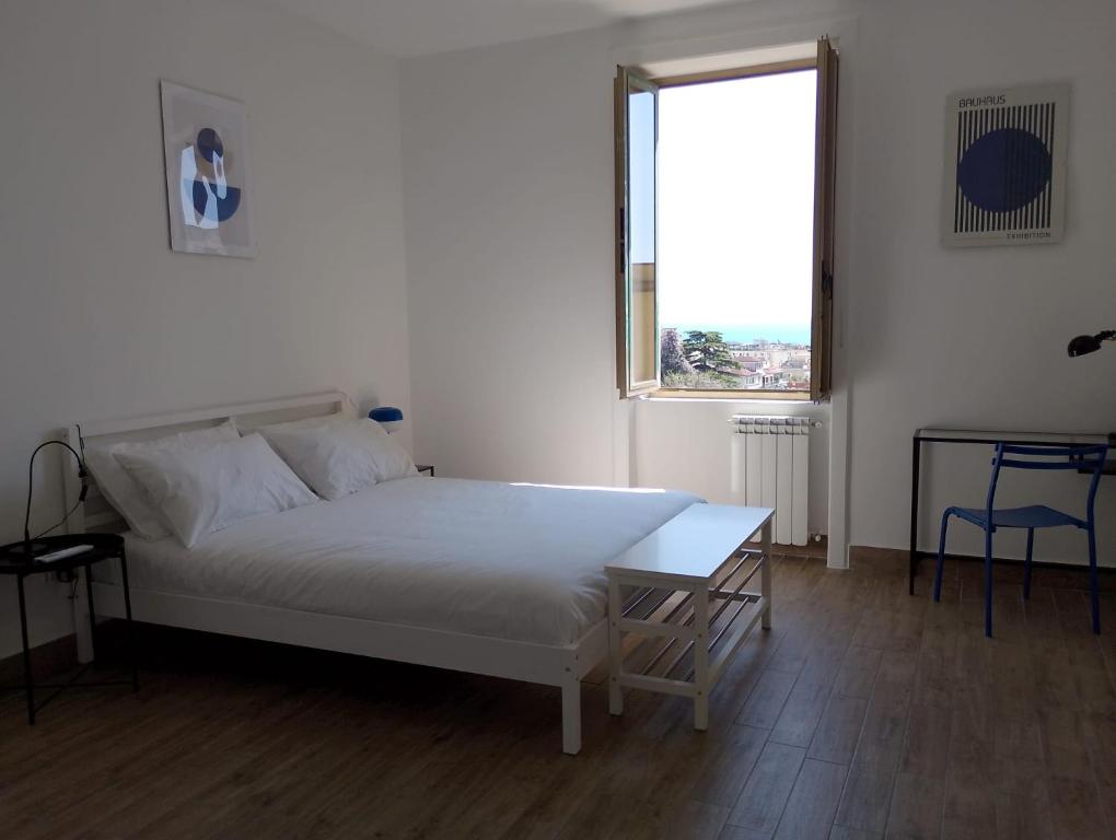a white bedroom with a bed and a window at Almarisa - appartamento vista mare in Salerno