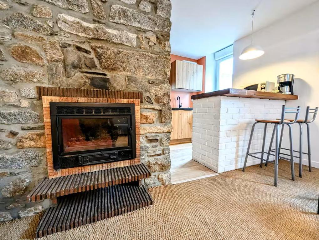 - une cheminée en pierre dans le salon avec un comptoir dans l'établissement Cathédrhalte - Le coeur historique, à Saint-Brieuc