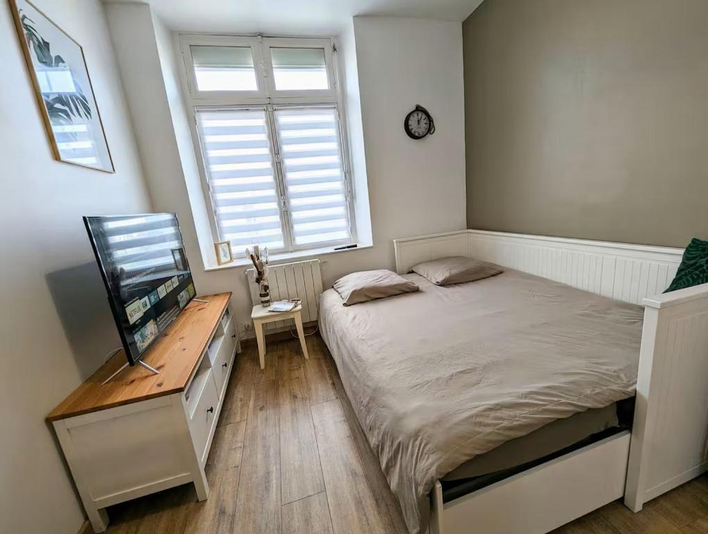 a bedroom with a bed and a desk and a window at Le Nid - studio cosy fraîchement rénové in Saint-Brieuc