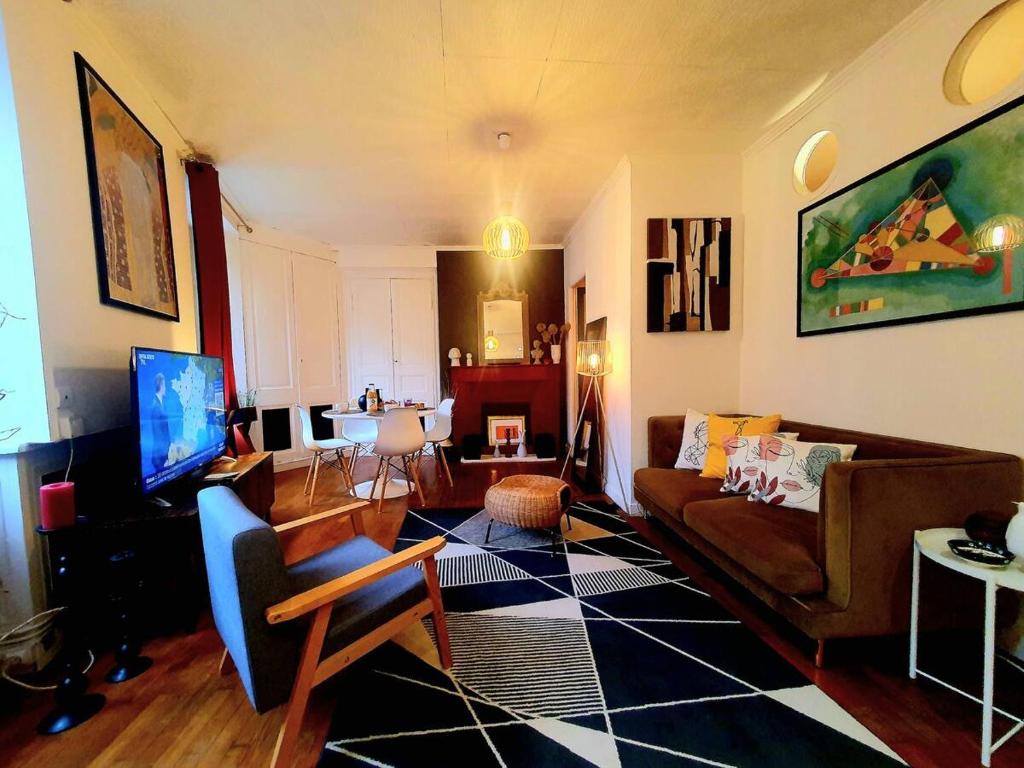 un salon avec un canapé et une télévision dans l'établissement Chez Jeanne, à Saint-Brieuc