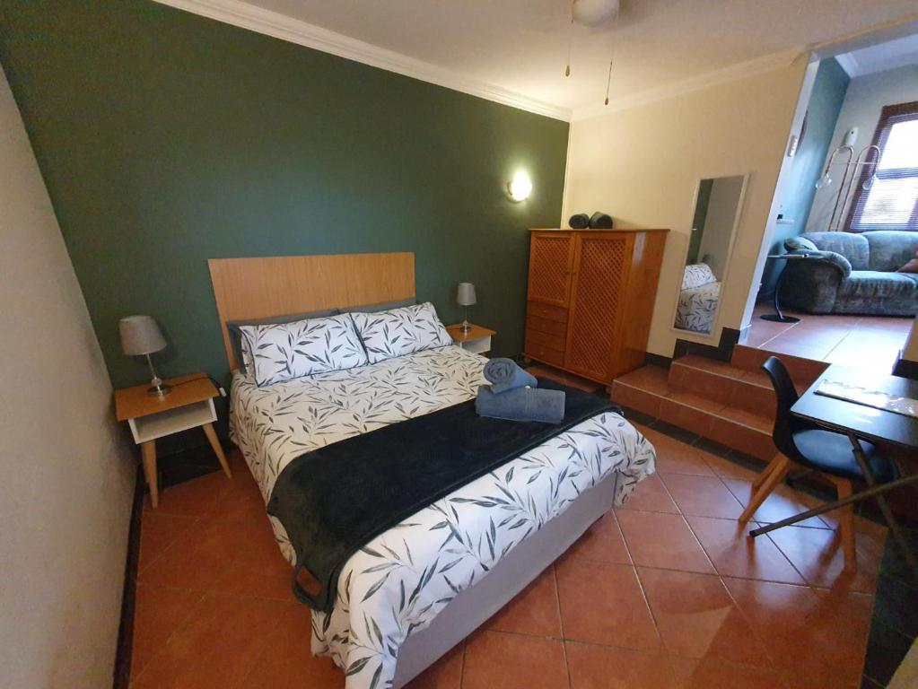 una camera da letto con un letto e una parete verde di Willow's Corner-Just like home! a Durban