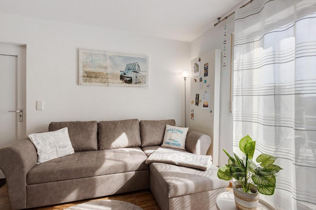 a living room with a couch and a plant at Lake House Boutique Ferienwohnung in Allensbach