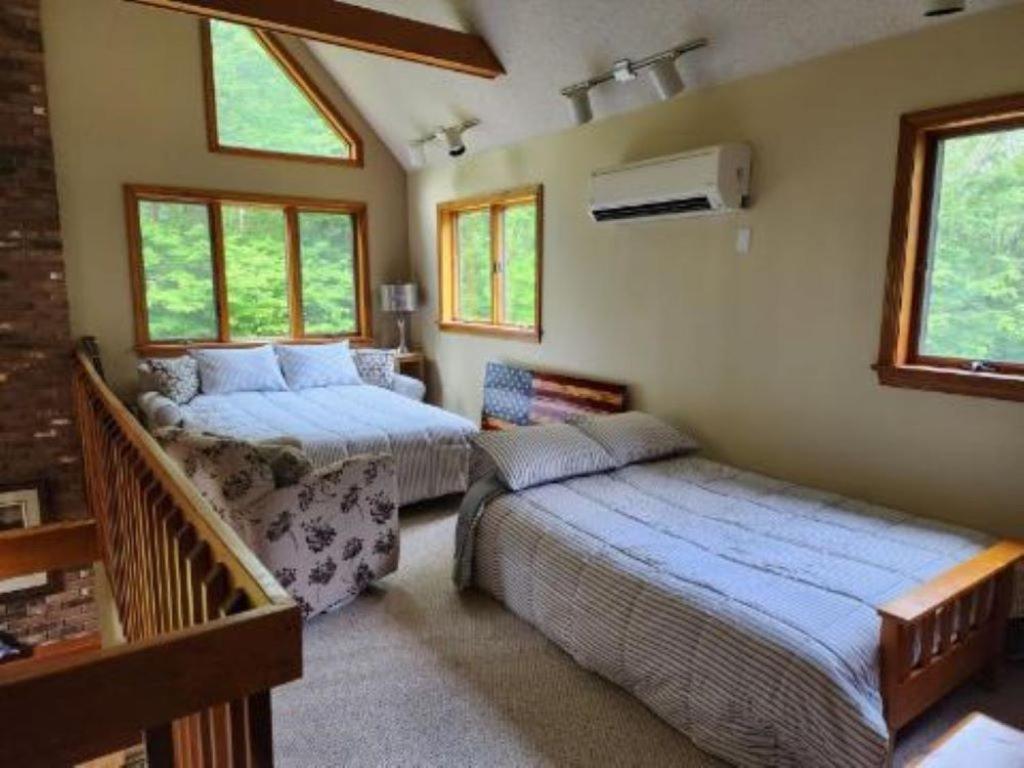 Cet appartement comprend une chambre avec deux lits et un balcon avec des fenêtres. dans l'établissement Mystic, Foxwoods, Beaches, Waterpark, Hells Kitchen!, à North Stonington