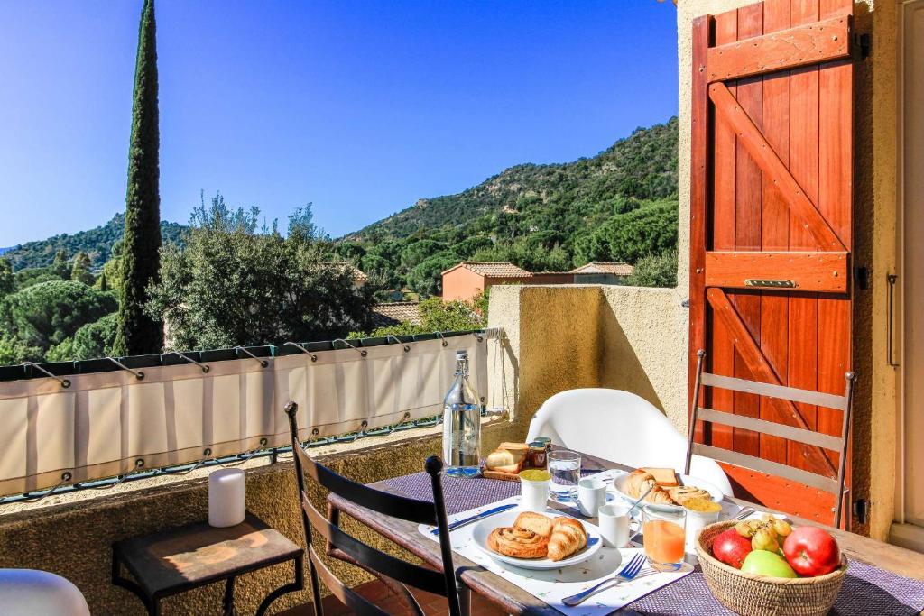 une table avec une assiette de nourriture sur un balcon dans l'établissement SELECT'so HOME - Superbe T2 avec vue mer pour un séjour relaxant - Piscine et Parking inclus - PARADISIA, au Lavandou