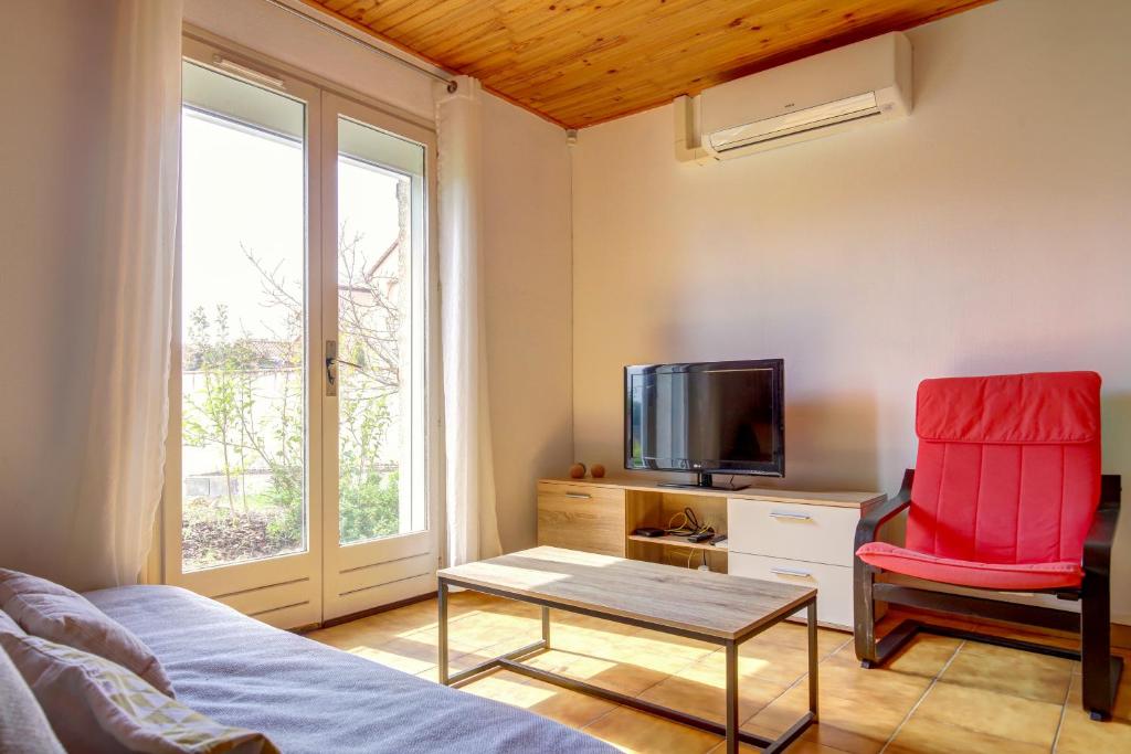 Una habitación con una cama, un televisor y una silla. en Le Van Gogh 3 chambres 4 lits, en Tournefeuille