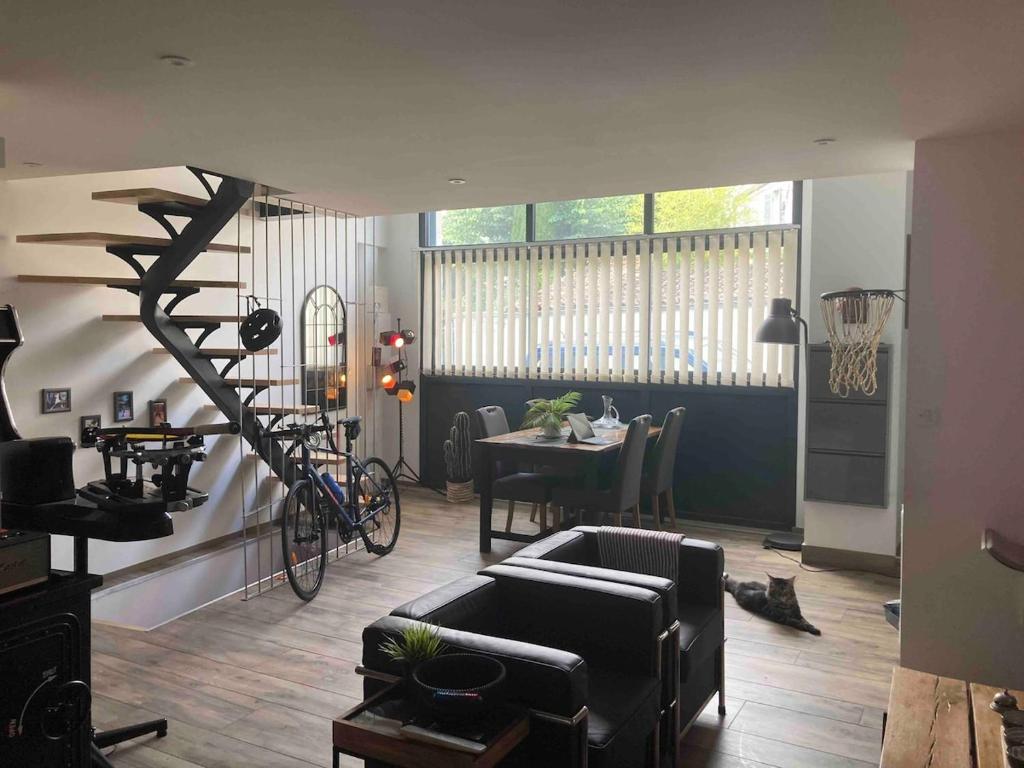 un salon avec un escalier en colimaçon et une table dans l'établissement Loft Hyper centre Saintes, à Saintes