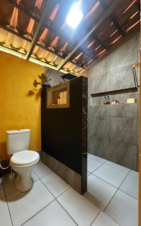 a bathroom with a toilet and a shower at Casa Raizes Pousada in Ilha Cotejuba