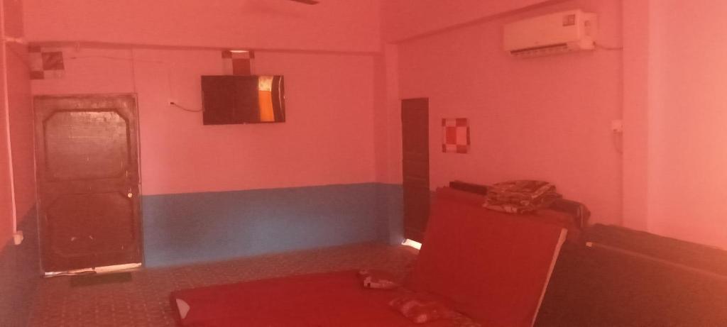 a room with a red room with a red couch and a door at Aadi Shankara canteen and guest house in Ayodhya