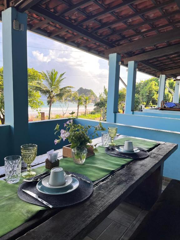 a wooden table with plates and napkins on it at Pousada do Joab - Fernando de Noronha in Fernando de Noronha