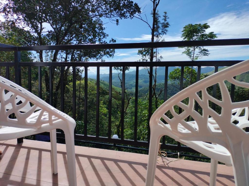 due sedie bianche sedute su un ponte con vista di Robin's Paradise Deluxe Villa a Vagamon