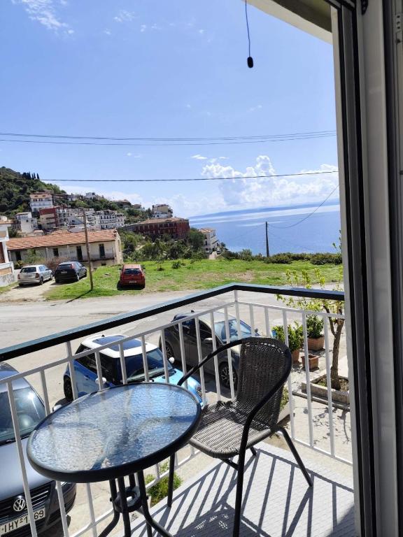 a table and chairs on a balcony with a view of the ocean at Dreams Street Apartment in Loutra Edipsou