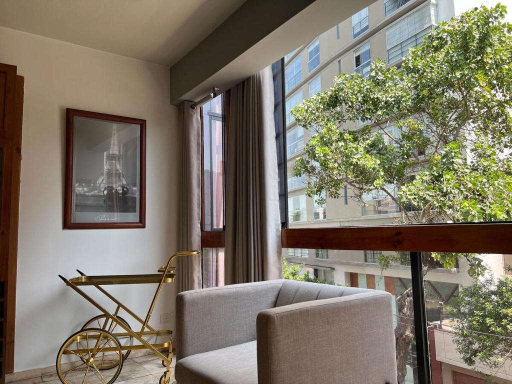a room with a chair and a bike in front of a window at View of the Pacific Ocean in Lima