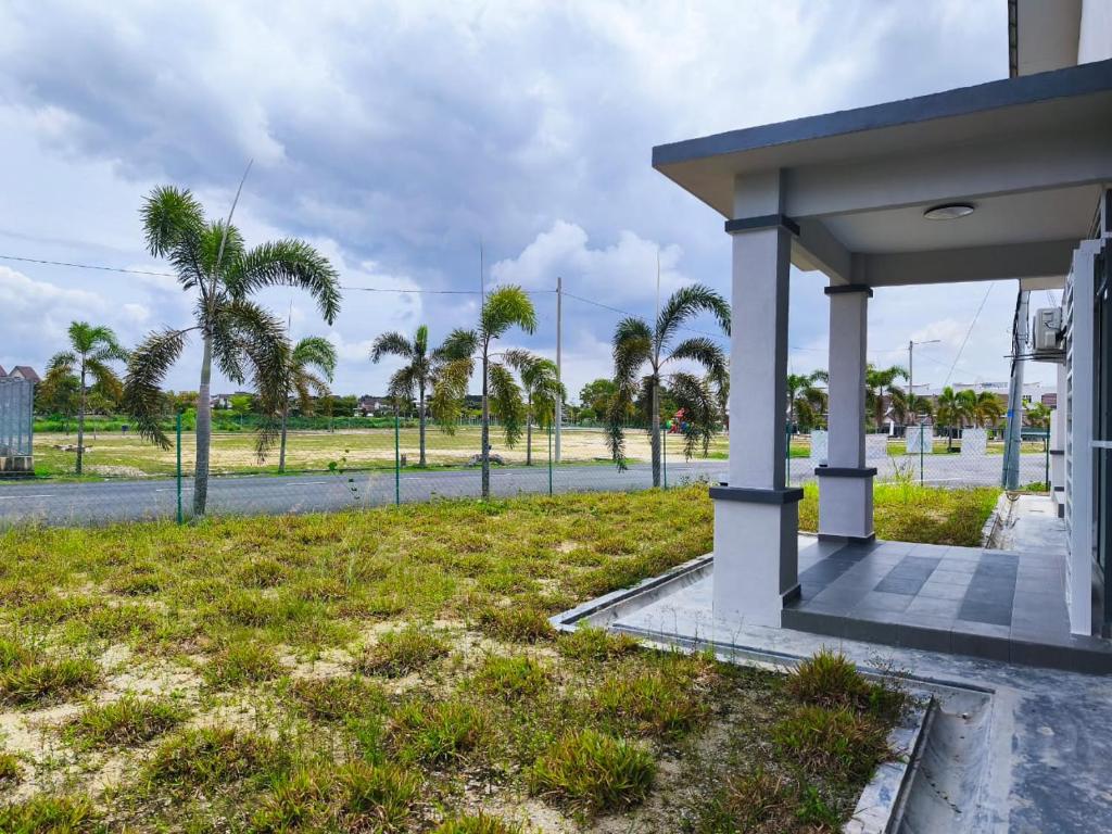 een tankstation met palmbomen op de achtergrond bij Ustazahhomestay in Bemban