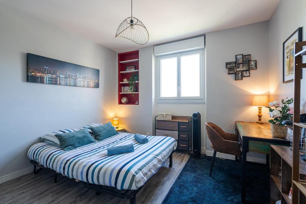 une chambre avec un lit et un bureau dans l'établissement le petit indus, à Angers