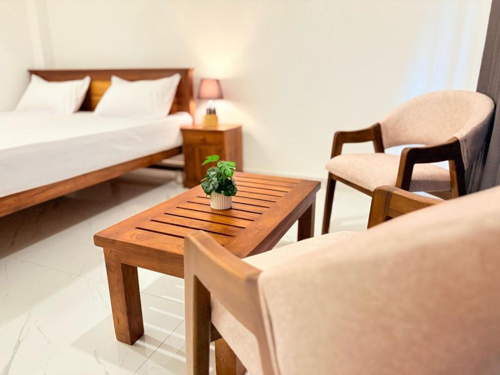 ein Zimmer mit einem Bett und einem Tisch und Stühlen in der Unterkunft Airport Heaven's Corner Home Stay Negombo in Etgala