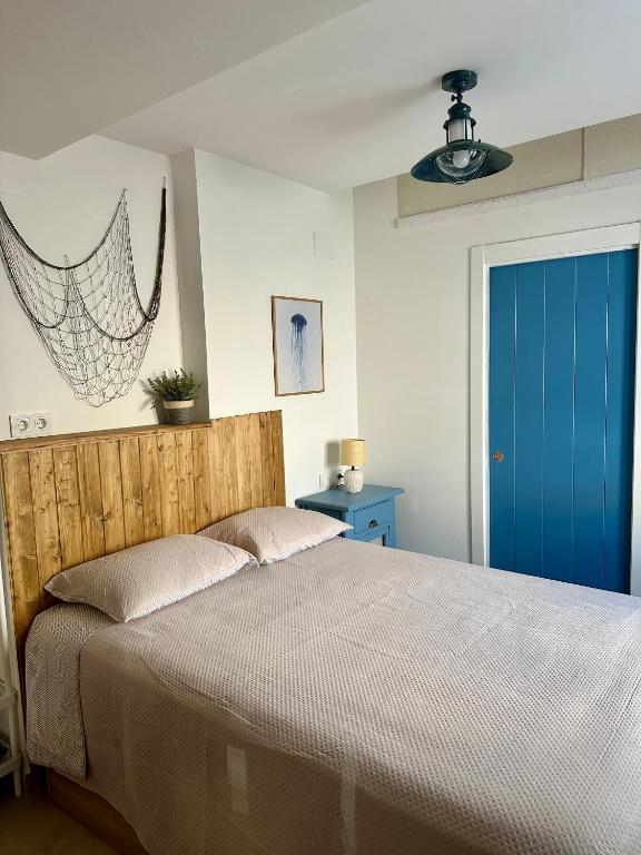 a bedroom with a bed and a blue door at La medusa flamenca in Santa Pola