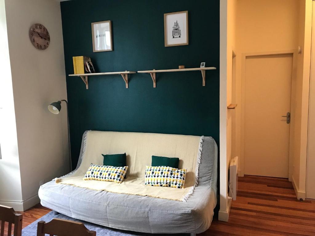 - un canapé dans un salon avec un mur vert dans l'établissement T2 Centre de Luchon, à Luchon