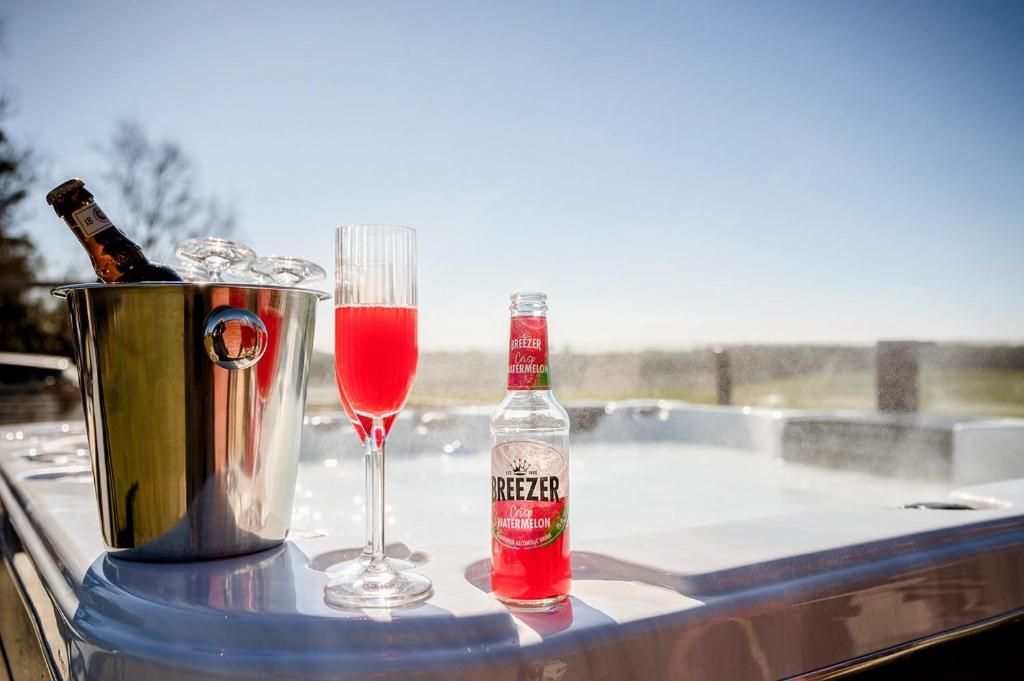 a table with a bottle and a glass of wine at Luxury Rural Retreat with Jacuzzi near Lund & Malmö in Kävlinge