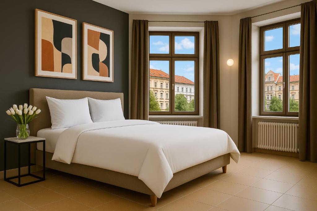 une chambre avec un grand lit blanc et des fenêtres dans l'établissement Bohemian Dreams Apartments and Suites by Dwellfort, à Prague