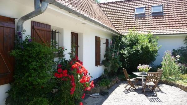 - une terrasse avec une table, des chaises et des fleurs dans l'établissement Au jet de pierre, à Saint-Inglevert